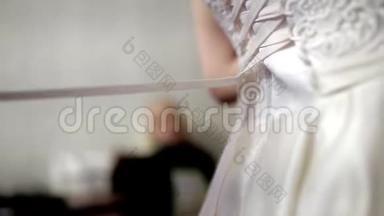 妈妈帮新娘穿上婚纱。 库存。 双手系一件婚纱